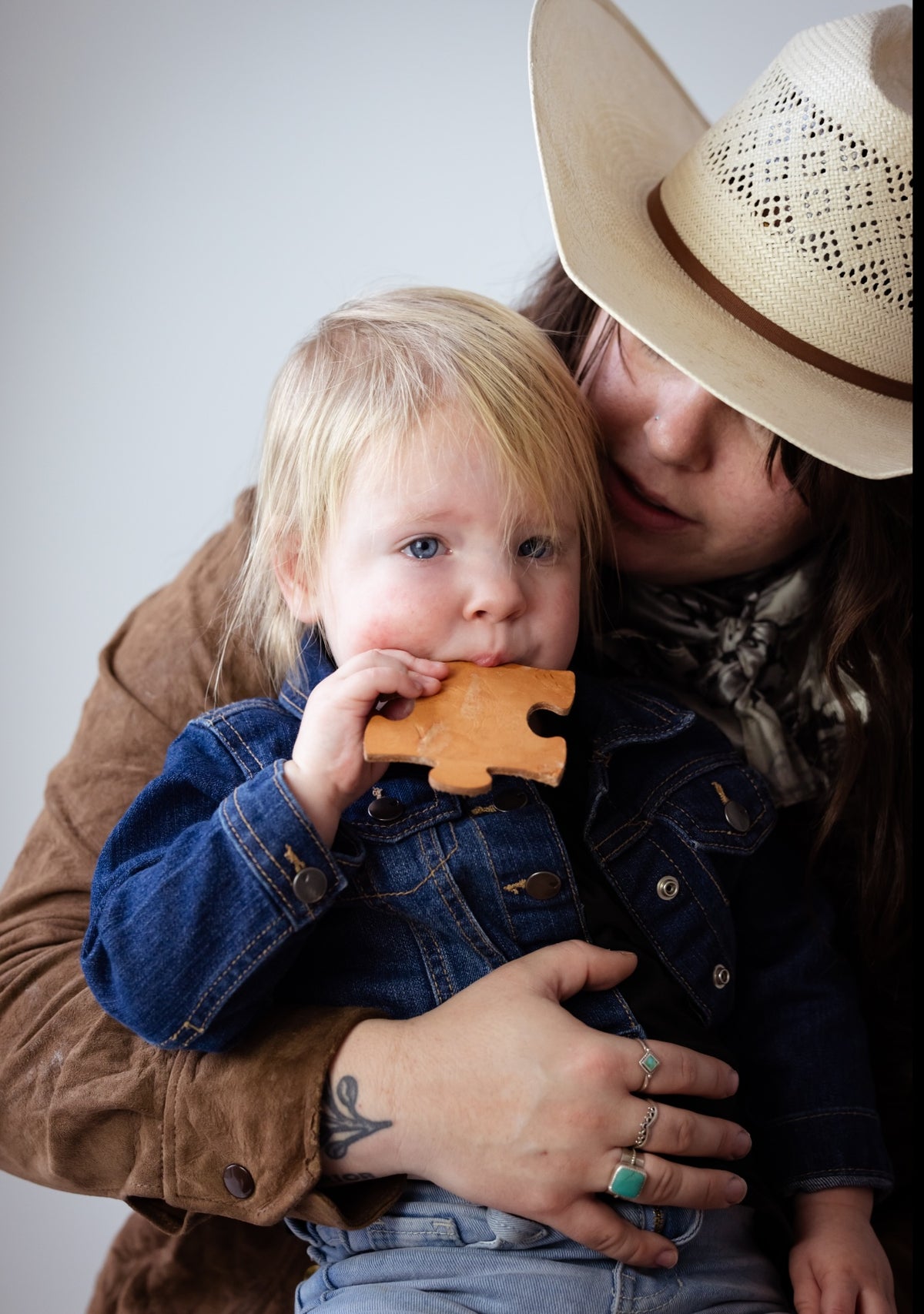 western mom mother holding and soothing baby chewing on natural teething toy for comfort 
