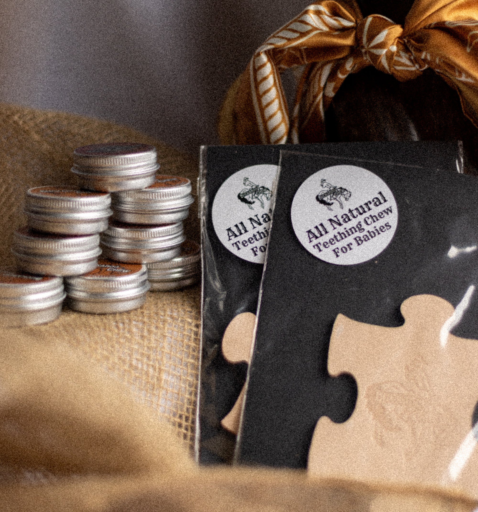 All Natural Teeth Powder packaging with a stack of small containers on a textured surface.